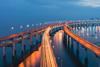 illuminated-curved-bridge-over-ocean-at-twilight_1080-720
