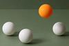 orange-ball-floating-above-white-balls-hero