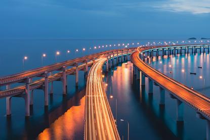 illuminated-curved-bridge-over-ocean-at-twilight_1080-720