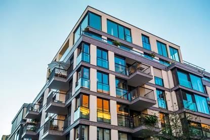 modern-corner-apartment-complex-with-blue-colored-windows-and-light-leaks