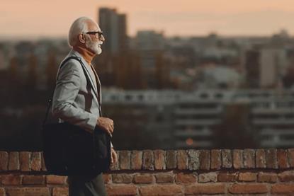 older-adult-walking-along-a-brick-wall-hero